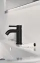 Schwarze Waschtischarmatur von Ideal Standard auf einem weißen Waschbecken, mit einem modernen, klaren Design und einem Push-Open Mechanismus.